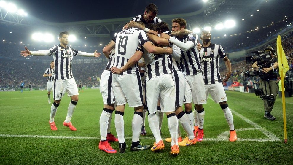 Juventus' forward from Argentina Carlos Tevez celebrates with teammates after scoring a penalty kick during the UEFA Champions League semi-final first leg football match Juventus vs Real Madrid on May 5, 2015 at the Juventus stadium in Turin.  AFP PHOTO / OLIVIER MORIN        (Photo credit should read OLIVIER MORIN/AFP/Getty Images)