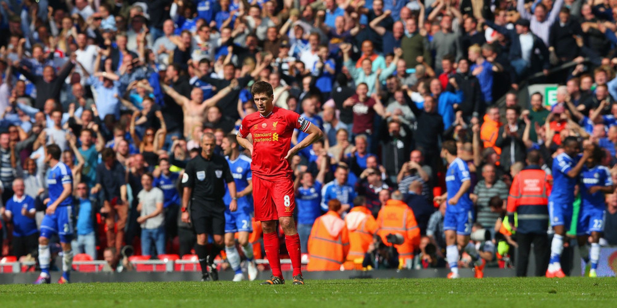 LIVERPOOL, ENGLAND - APRIL 27:  A dejected Steven Gerrard of Liverpool looks on as the Chelsea fans celebrate after Willian of Chelsea scored their second goal during the Barclays Premier League match between Liverpool and Chelsea at Anfield on April 27, 2014 in Liverpool, England.  (Photo by Clive Brunskill/Getty Images)